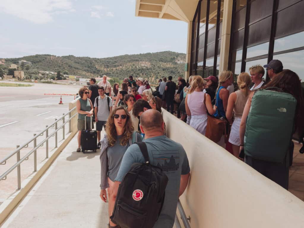 A crowd of passengers waiting to board a plane at the Skiathos Airport in Greece