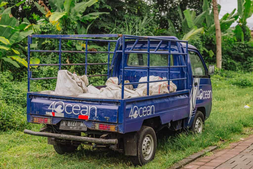 A garbage truck hauling debris away from a Bali beach